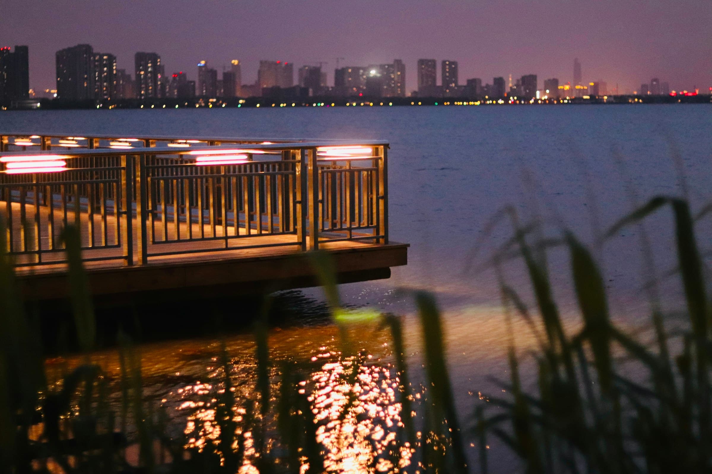 The terrace at golden hour with guests, the water and lower Manhattan behind